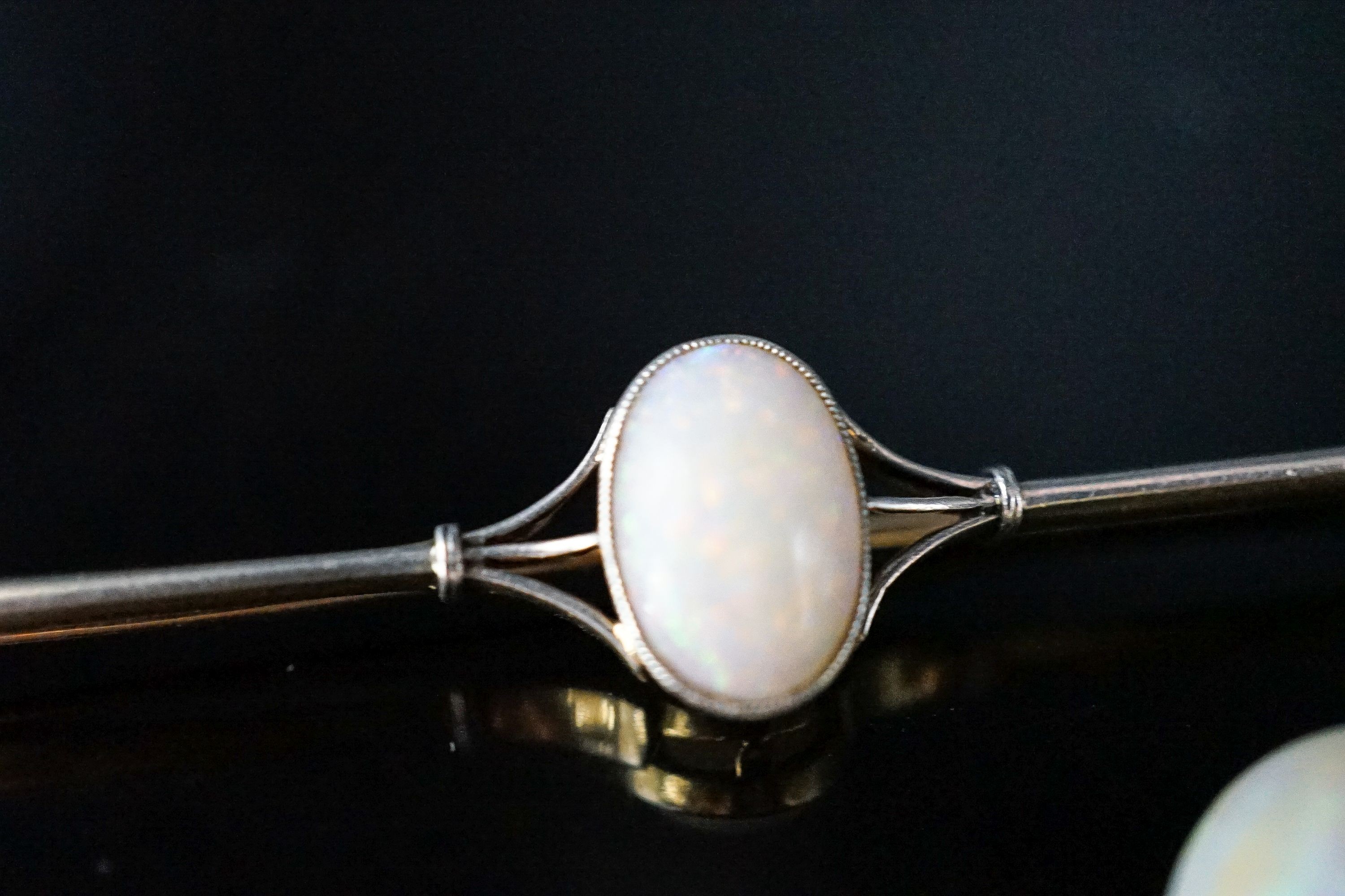 A yellow metal and white opal set bar brooch, 63mm, gross 4.9 grams and a loose white opal.